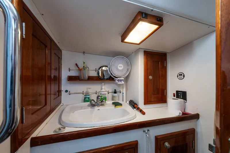 Slide: The Image of Compact bathroom in a 1993 Van De Stadt Samoa 47 yacht, featuring wooden cabinets and a sink. - 22