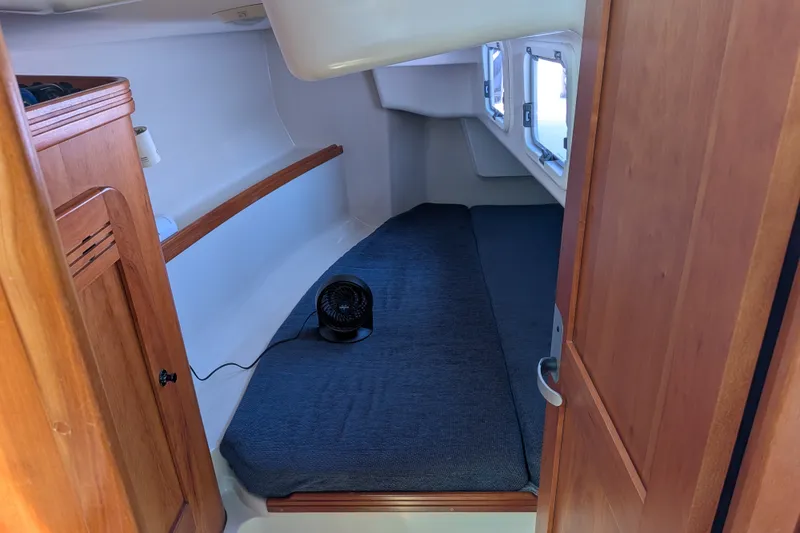 Slide: The Image of Cozy cabin interior of a 2005 C&C 115 sailboat with a small fan and wooden accents. - 46
