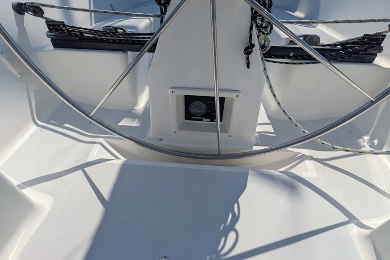 Slide: The Image of Steering wheel of a 2005 C&C 115 sailboat, featuring ropes and control panel. - 14