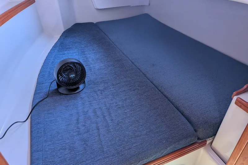 Slide: The Image of Small cabin interior with blue cushions and a portable fan on a C&C 115 sailboat. - 47