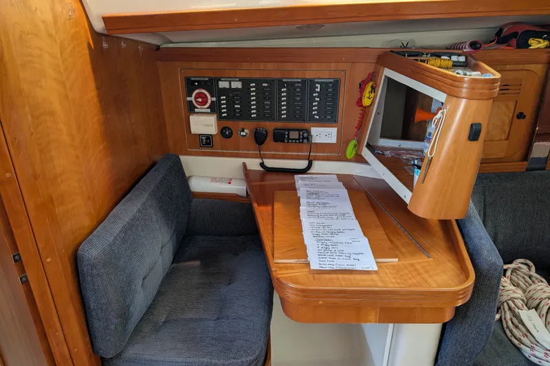 Slide: The Image of Navigation station inside a 2005 C&C 115 sailboat with control panel and seating. - 34