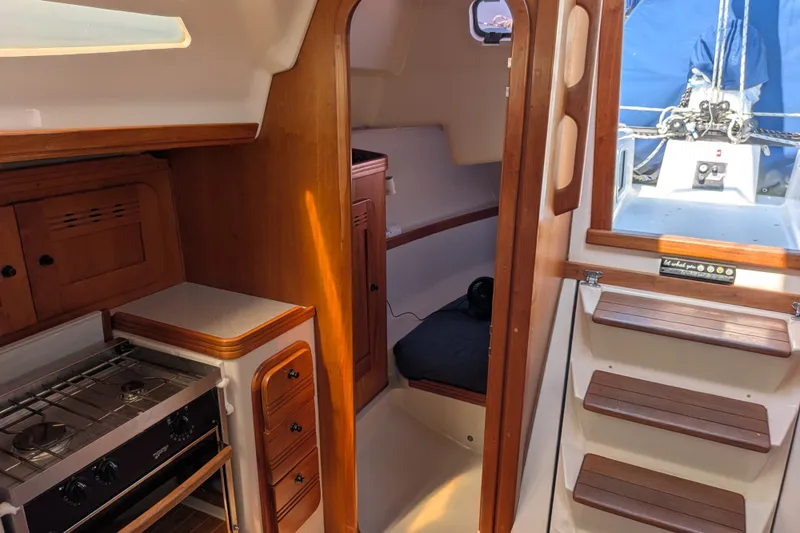 Slide: The Image of Interior of a 2005 C&C 115 sailboat featuring a compact kitchen and cozy cabin space. - 45