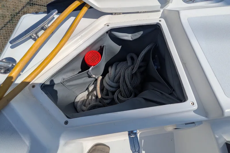 Slide: The Image of Open storage compartment on a 2005 C&C 115 sailboat with rope and hose. - 21