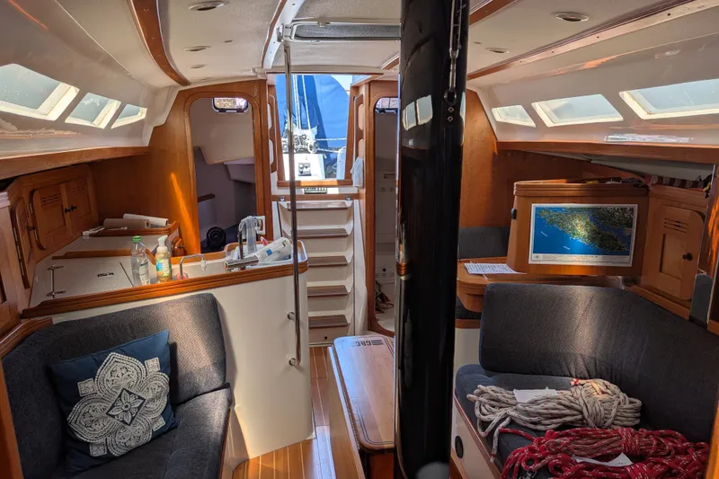 Slide: The Image of Interior of a 2005 C&C 115 sailboat, featuring cozy seating and nautical decor. - 44