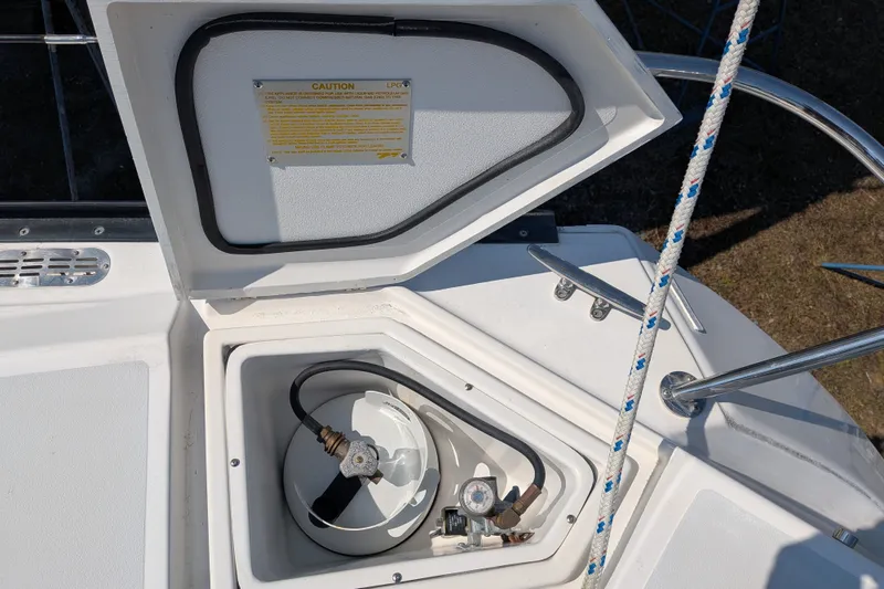 Slide: The Image of Open storage compartment on a 2005 C&C 115 boat, showing LPG tank and caution label. - 20