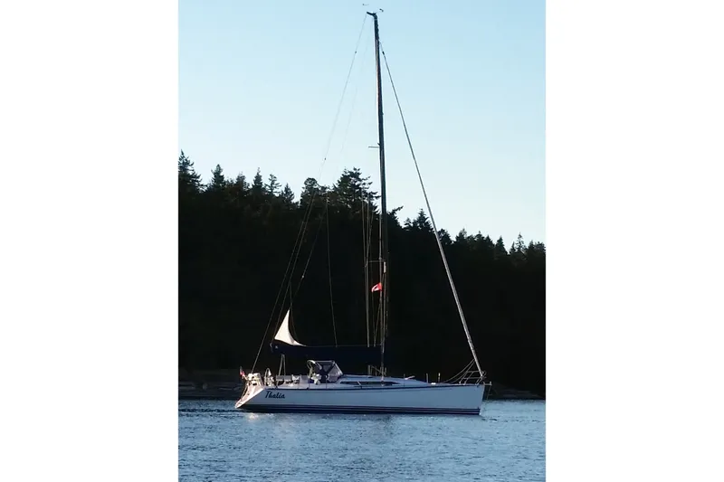 The Image of Sailboat on calm water, C&C 115 model, 2005, with forested background. - 1