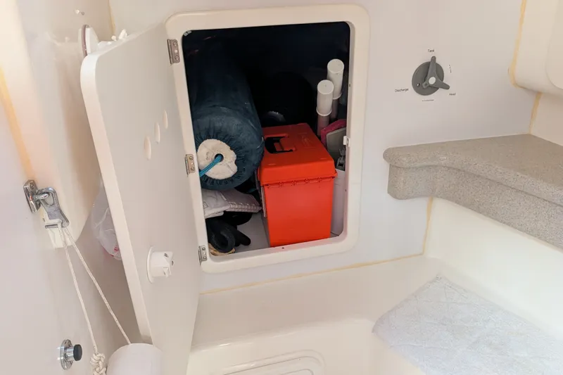 Slide: The Image of Storage compartment on a 2005 C&C 115 sailboat, containing various items and equipment. - 49