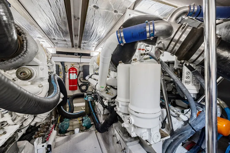 Slide: The Image of Engine room of 2007 Sea Ray 58 Sedan Bridge yacht, featuring complex machinery and fire extinguisher. - 78