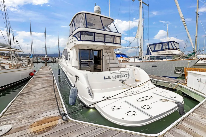 Slide: The Image of 2007 Sea Ray 58 Sedan Bridge yacht docked at marina, clear sky background. - 24