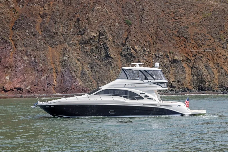 Slide: The Image of 2007 Sea Ray 58 Sedan Bridge yacht cruising near rocky shoreline. - 17