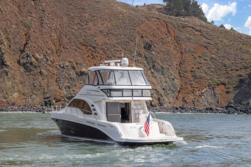 Slide: The Image of 2007 Sea Ray 58 Sedan Bridge yacht cruising near rocky coastline. - 22