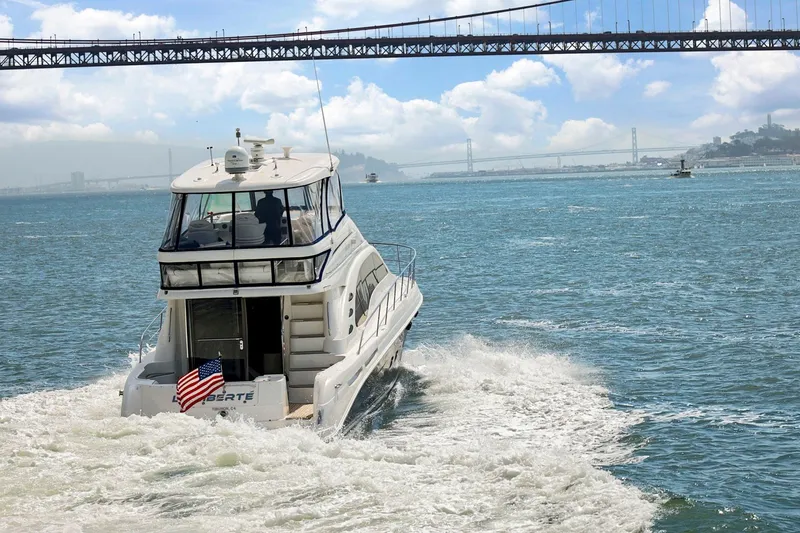 Slide: The Image of 2007 Sea Ray 58 Sedan Bridge yacht cruising under a bridge on a sunny day. - 10