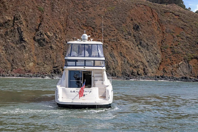 Slide: The Image of 2007 Sea Ray 58 Sedan Bridge yacht cruising near rocky coastline. - 21