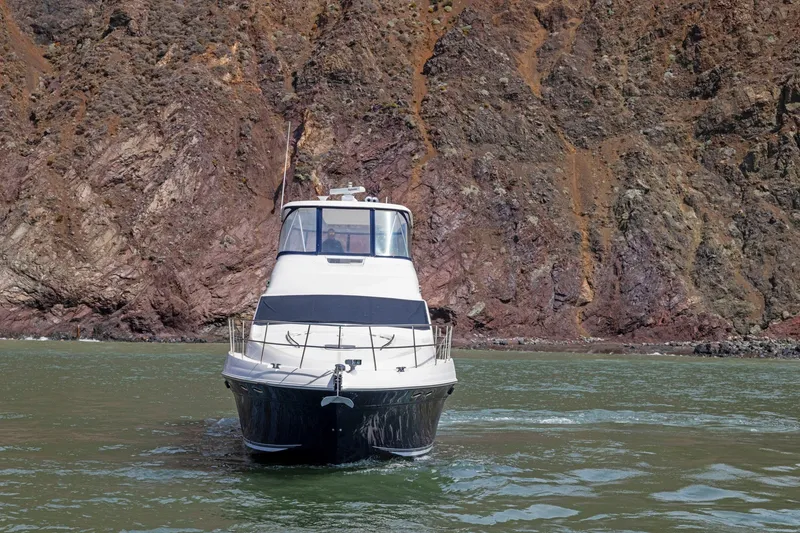 Slide: The Image of 2007 Sea Ray 58 Sedan Bridge yacht cruising near rocky shoreline. - 18