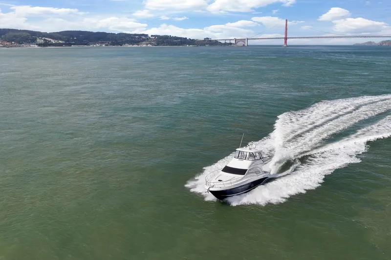 Slide: The Image of 2007 Sea Ray 58 Sedan Bridge cruising near a bridge on a sunny day. - 16