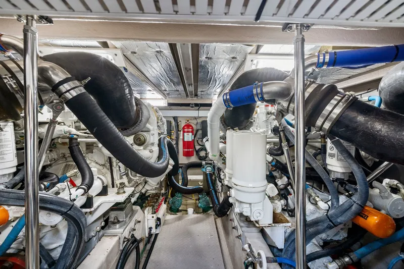 Slide: The Image of Engine room of 2007 Sea Ray 58 Sedan Bridge yacht, featuring complex machinery and piping. - 77