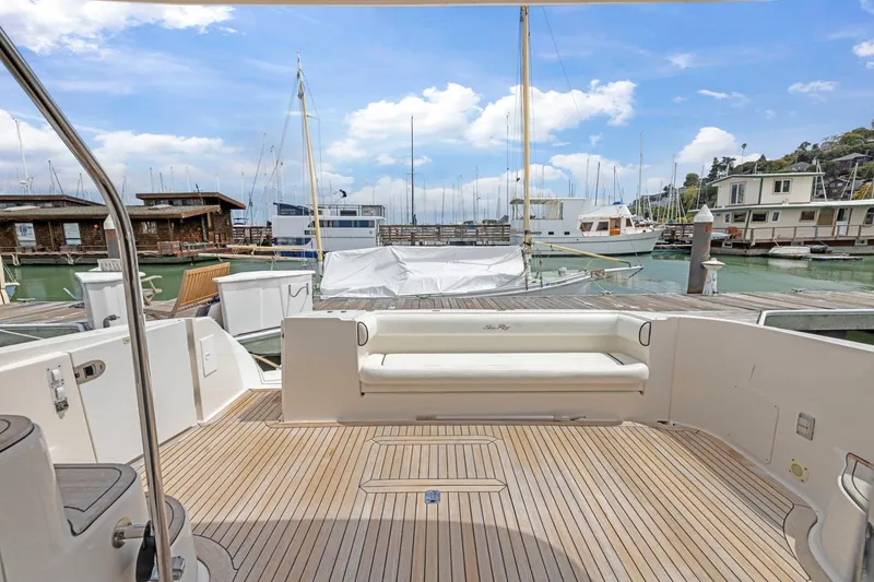 Slide: The Image of 2007 Sea Ray 58 Sedan Bridge yacht docked at marina, featuring spacious deck and seating. - 30