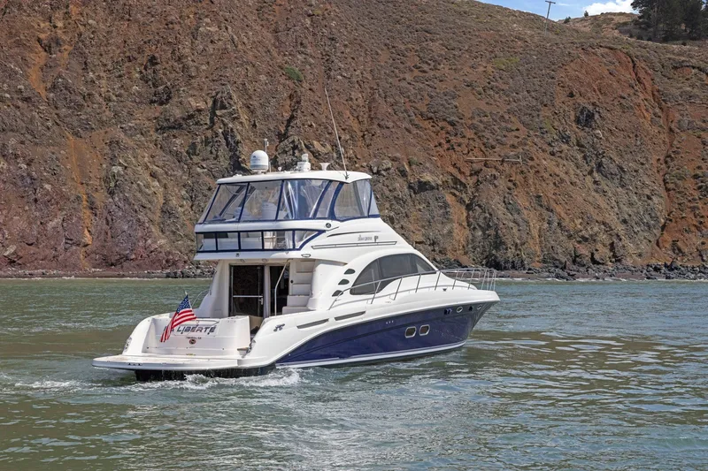 Slide: The Image of 2007 Sea Ray 58 Sedan Bridge yacht cruising near rocky shoreline. - 20