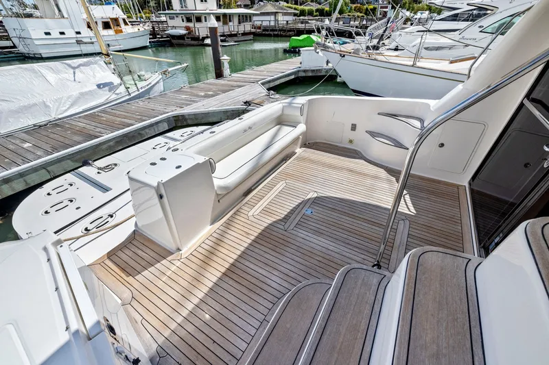 Slide: The Image of 2007 Sea Ray 58 Sedan Bridge yacht with spacious teak deck at marina. - 76