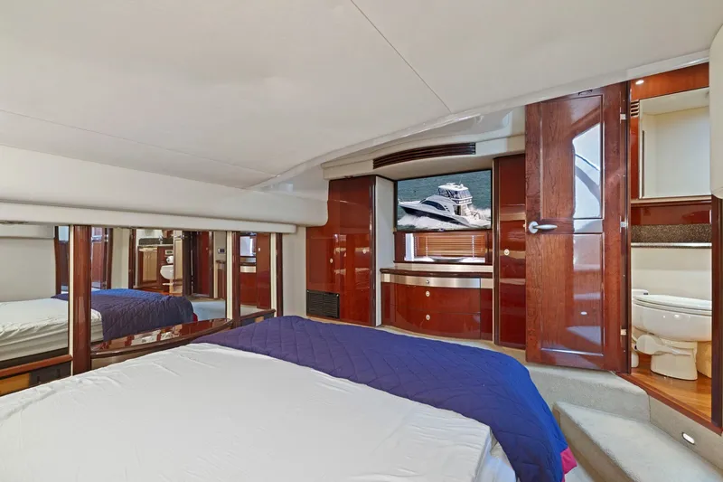 Slide: The Image of Luxurious 2007 Sea Ray 58 Sedan Bridge yacht bedroom with elegant wood finishes and ensuite bathroom. - 59