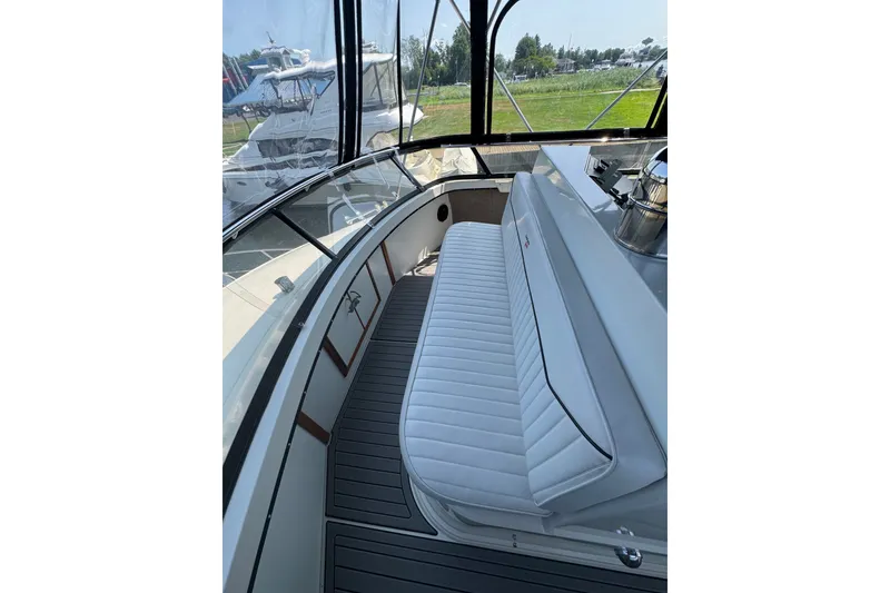 Slide: The Image of 1990 Carver 3807 Aft Cabin Motor Yacht interior with white seating and panoramic windows. - 48