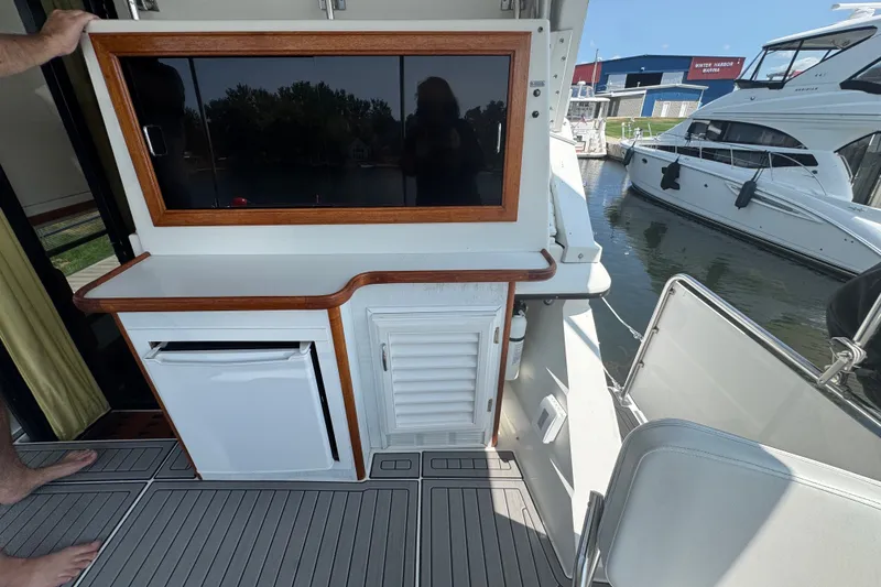 Slide: The Image of 1990 Carver 3807 Aft Cabin Motor Yacht interior with kitchenette and marina view. - 35