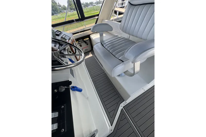 Slide: The Image of 1990 Carver 3807 Aft Cabin Motor Yacht helm with steering wheel and captain's chair. - 44
