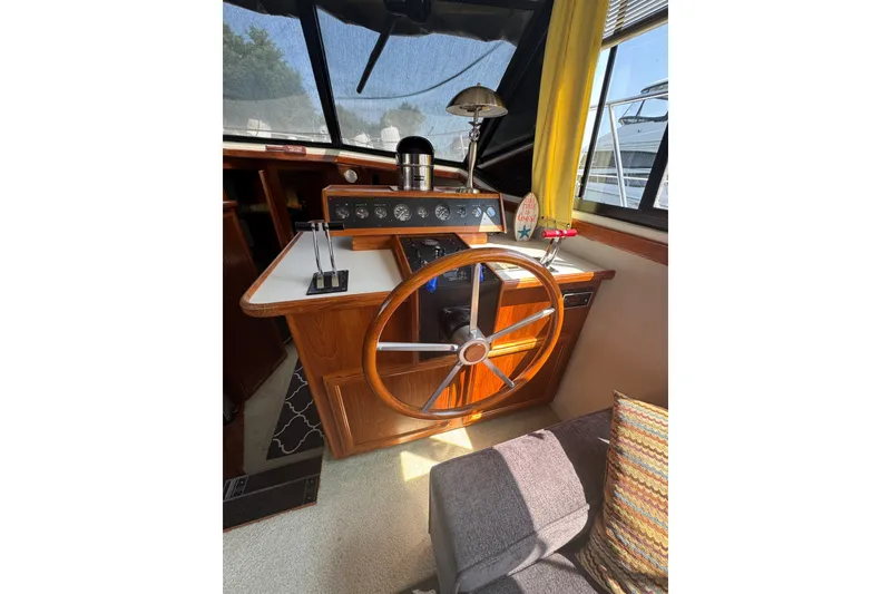 Slide: The Image of 1990 Carver 3807 Aft Cabin Motor Yacht helm with wooden steering wheel and control panel. - 20