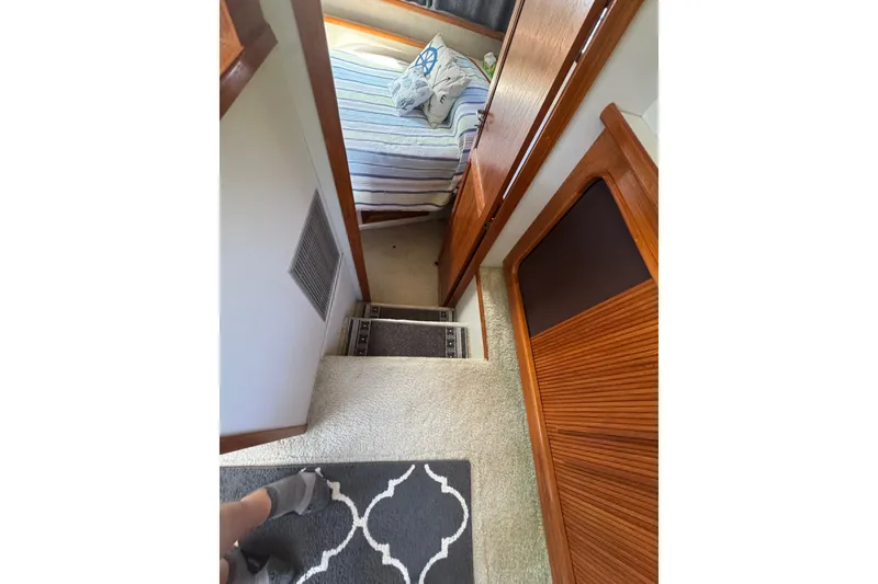 Slide: The Image of Interior view of 1990 Carver 3807 Aft Cabin Motor Yacht, featuring stairs and cozy bedroom. - 26