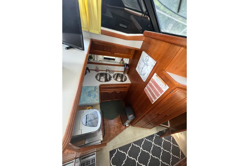 Slide: The Image of Interior of 1990 Carver 3807 Aft Cabin Motor Yacht with wood cabinetry and dual sinks. - 17
