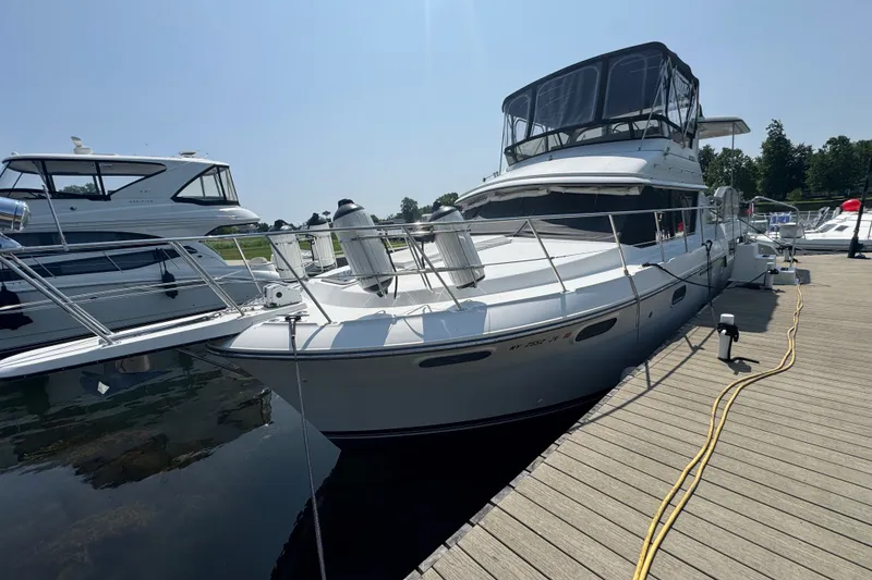 Slide: The Image of 1990 Carver 3807 Aft Cabin Motor Yacht docked at marina under clear sky. - 4