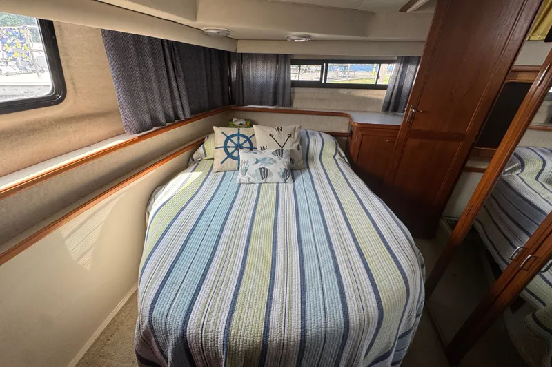 Slide: The Image of Cozy bedroom in 1990 Carver 3807 Aft Cabin Motor Yacht with striped bedding. - 29