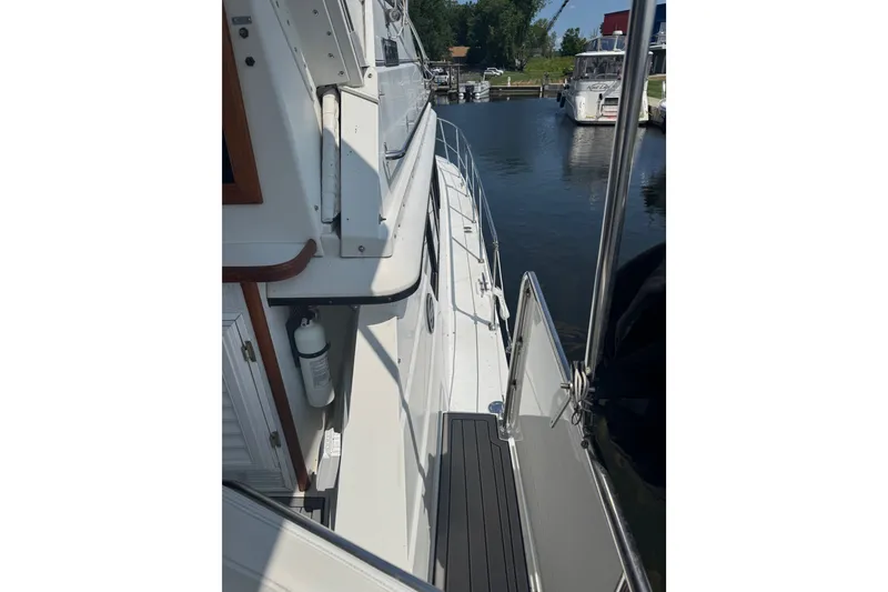 Slide: The Image of 1990 Carver 3807 Aft Cabin Motor Yacht docked, showcasing side deck and railing. - 9