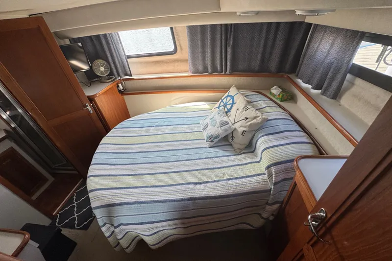 Slide: The Image of Cozy bedroom in 1990 Carver 3807 Aft Cabin Motor Yacht with striped bedding and nautical decor. - 25