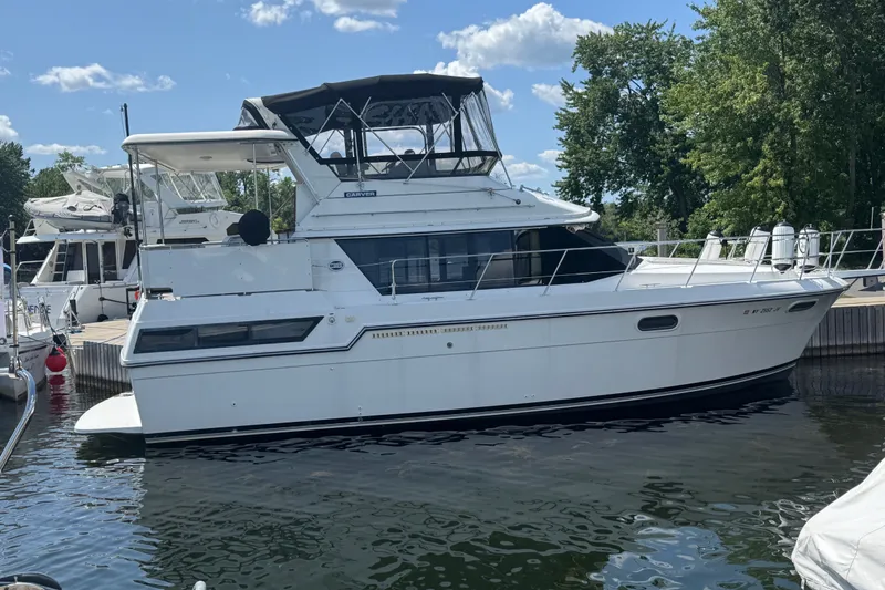 Slide: The Image of 1990 Carver 3807 Aft Cabin Motor Yacht docked at marina under blue sky. - 1