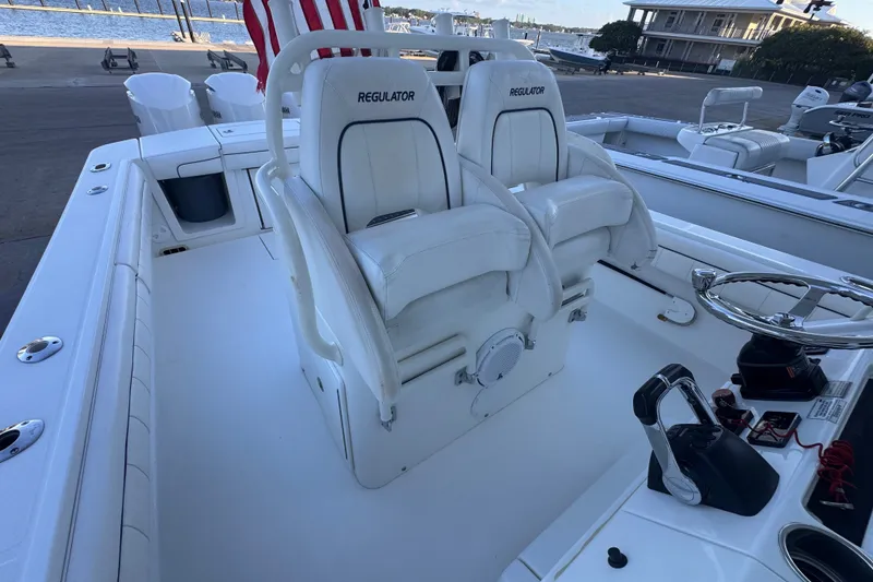 Slide: The Image of 2016 Regulator 34 boat interior with dual white captain's chairs and steering console. - 6