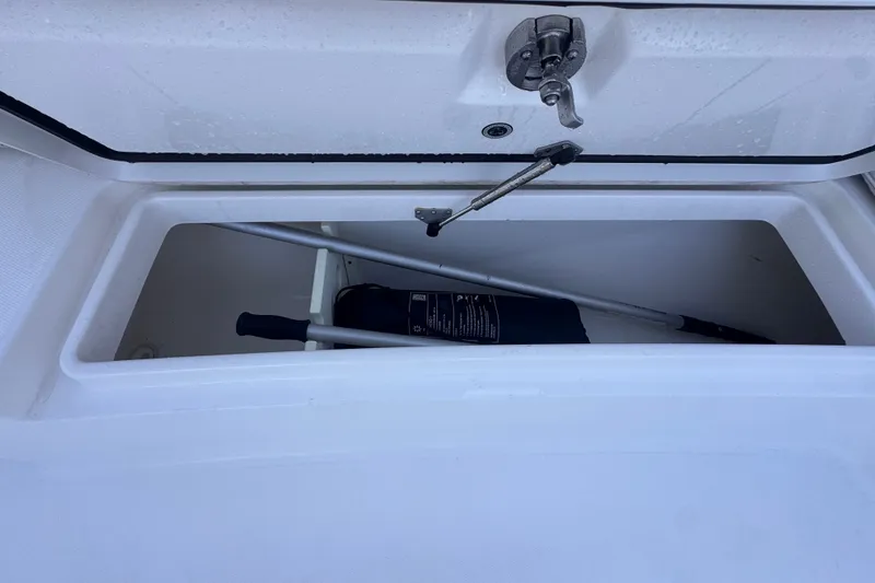 Slide: The Image of Storage compartment on a 2016 Regulator 34 boat, containing a paddle and equipment. - 27