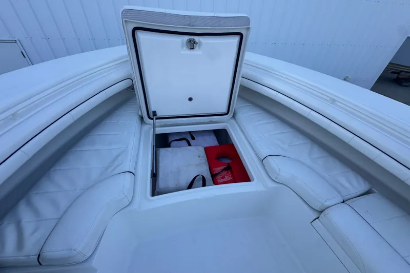Slide: The Image of Open storage compartment on 2016 Regulator 34 boat with white seating and safety equipment. - 26