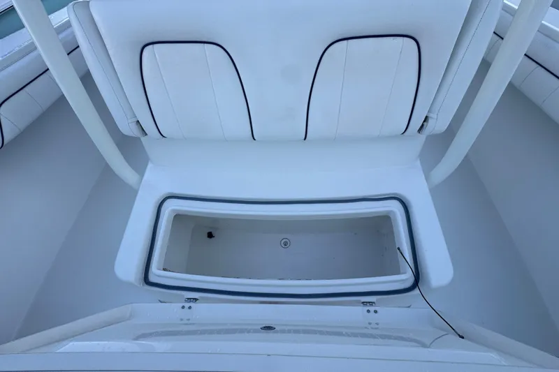 Slide: The Image of 2016 Regulator 34 boat interior with storage compartment and cushioned seating. - 12