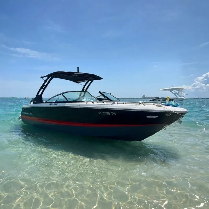 The Image of 2024 Chaparral 250 OSX boat in shallow turquoise water, featuring sleek black and red design. - 0