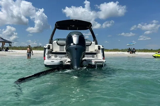 Slide: The Image of 2024 Chaparral 250 OSX boat in clear water near a sandy beach. - 6