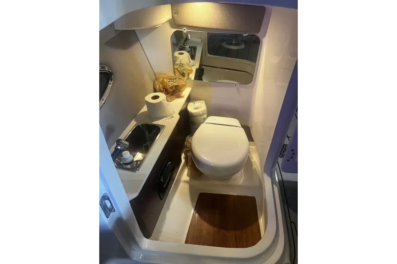 Slide: The Image of 2024 Chaparral 250 OSX boat bathroom with sink, toilet, and mirror. - 18