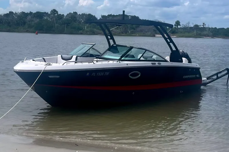 Slide: The Image of 2024 Chaparral 250 OSX boat anchored on a calm shoreline. - 10