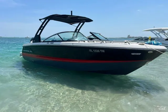The Image of 2024 Chaparral 250 OSX boat in shallow turquoise water, featuring sleek black and red design. - 1