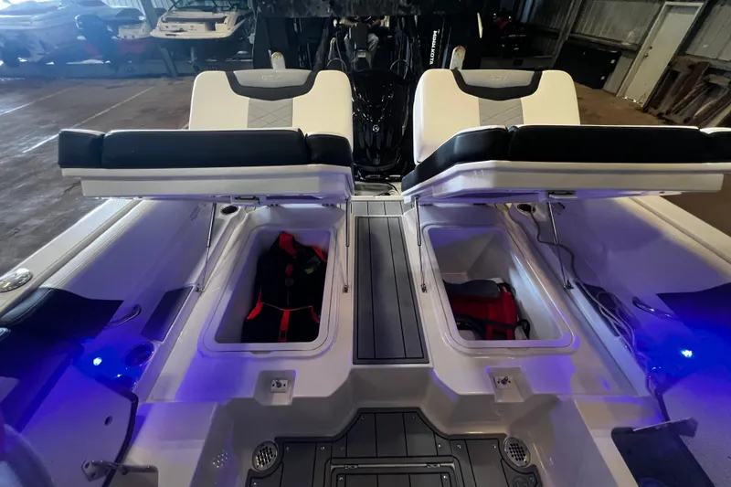 Slide: The Image of 2024 Chaparral 250 OSX boat interior with open storage compartments and seating. - 17