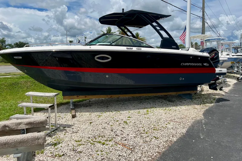 Slide: The Image of 2024 Chaparral 250 OSX boat displayed outdoors on gravel surface. - 9