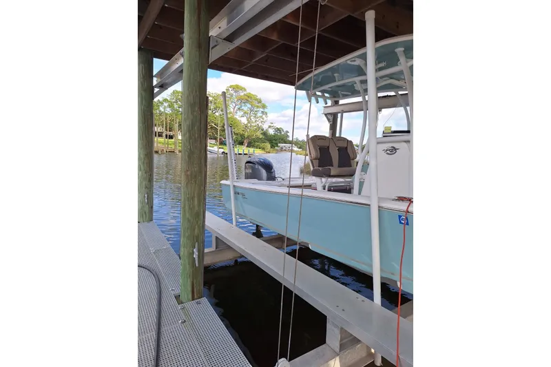 The Image of 2022 Tidewater 2500 Carolina Bay boat docked on a serene waterfront. - 4