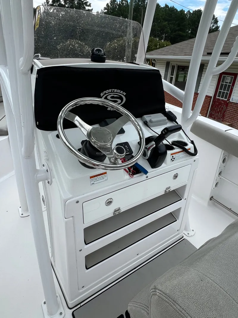 Slide: The Image of The image shows the helm of a 2021 Sportsman Open 232 Center Console boat. - 15
