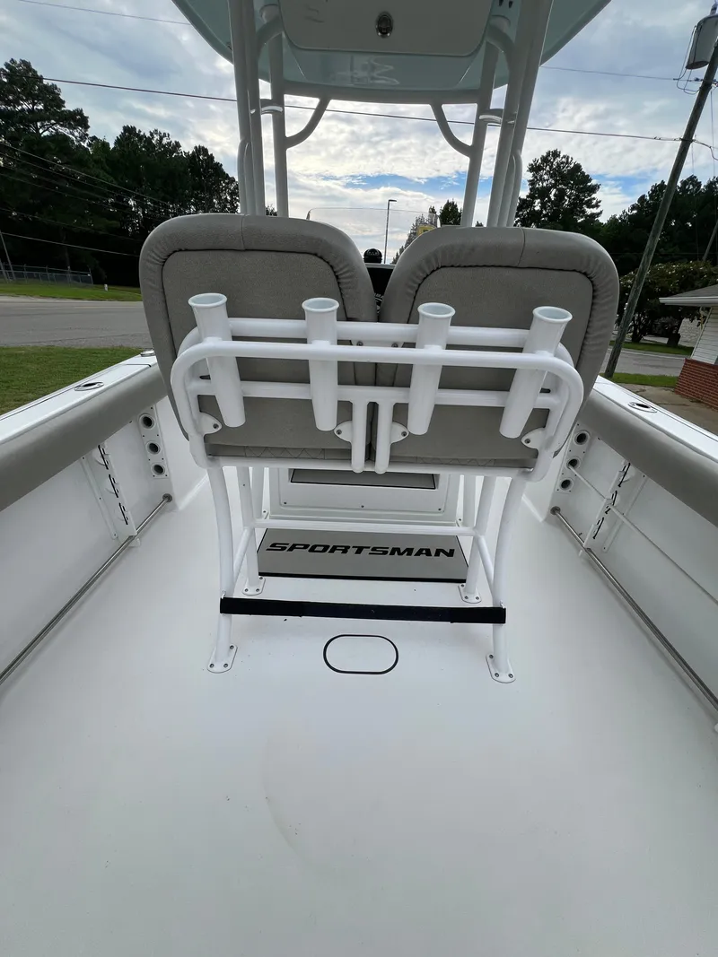 Slide: The Image of The image shows the cockpit of a 2021 Sportsman Open 232 Center Console boat with bench seating and rod holders. - 22