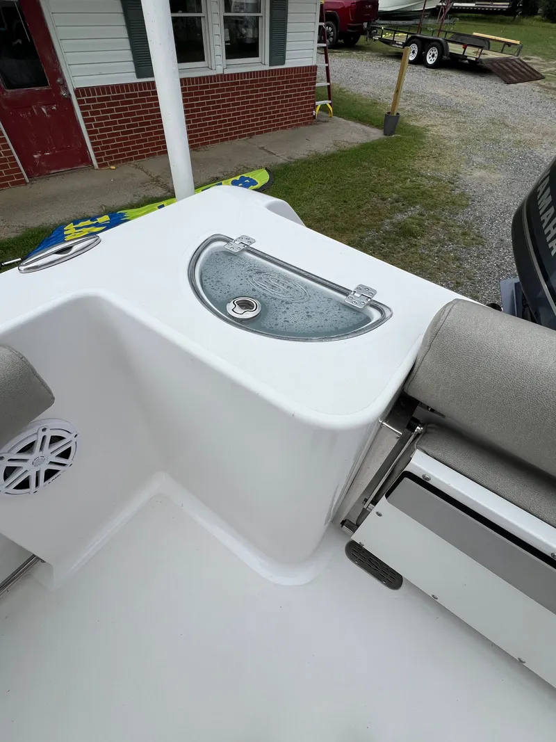 Slide: The Image of The image shows the deck of a 2021 Sportsman Open 232 Center Console boat with a seating area. - 27